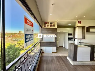 Sala de estar com vista para a paisagem externa através de uma grande janela.
