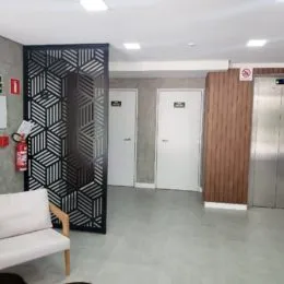 Hall de entrada com portas escuras e brancas.