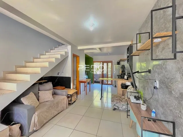 Ambiente interno de sala de estar com escadaria e área de passagem em imóvel no Brasil.