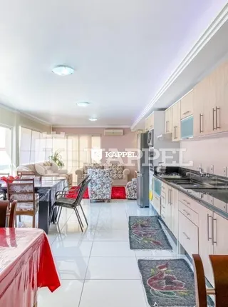 Foto interna de uma sala de estar com iluminação clara e móveis.