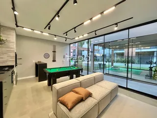 Sala de estar moderna com mesa de bilhar e portas de vidro que dão para o exterior.