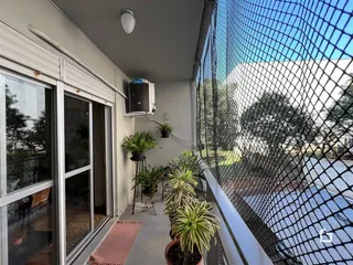 Vista da varanda de uma residência em Lajeado, Brasil, com plantas e grade de segurança.