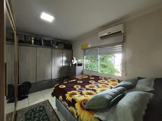 Quarto com armários em madeira e cama.