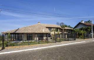 Fachada de uma casa em Lajeado, Brasil com cerca e muro de ferro.