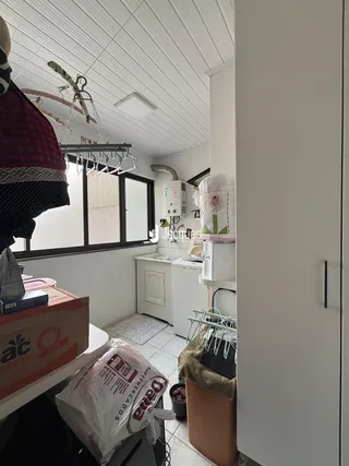 Vista interna de uma cozinha com janela e piso de cerâmica.