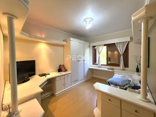 Quarto com armários embutidos e piso de madeira em imóvel no Brasil.