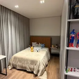 Quarto com cama e cabeceira de madeira.