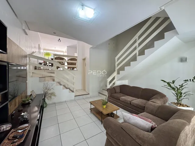 Sala de estar com sofá e escadaria em um imóvel no Brasil.