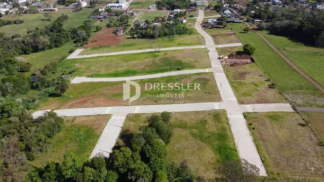 Vista aérea de uma propriedade rural com áreas gramadas e estradas de terra.