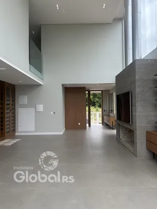 Vista interna de um hall moderno com paredes brancas e piso de concreto.