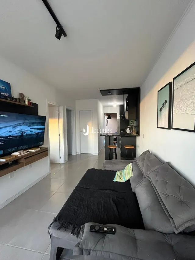 Foto de uma sala de estar com sofá e televisão.