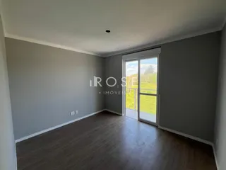 Sala de estar com piso de madeira e porta de vidro que dá para o jardim.