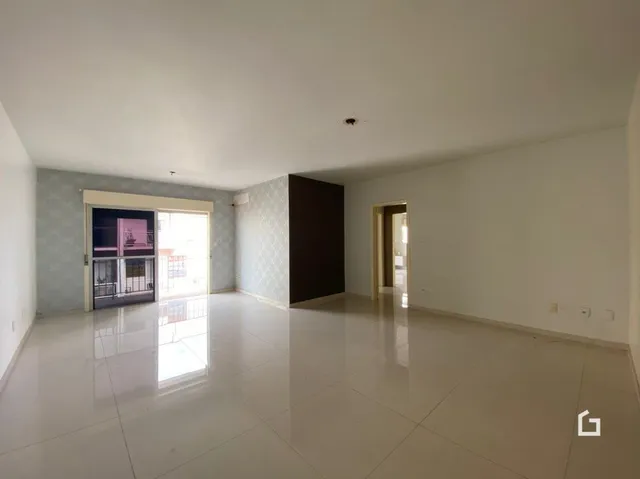 Ambiente interno de uma sala ampla com piso claro.