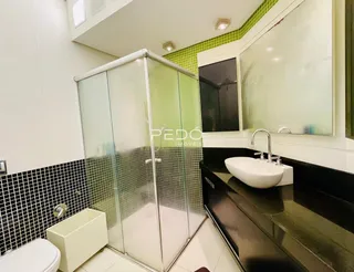Esta é uma foto de um banheiro com box de vidro e revestimento de azulejos pretos e brancos.