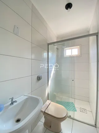 Foto interna de um banheiro com banheira e box de vidro.