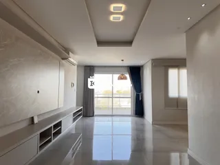 Sala de estar ampla com piso claro e portas de vidro que dão acesso ao exterior.