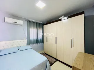 Quarto com cama e armário de madeira em um imóvel no Brasil.