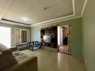 Sala de estar com sofá e painel de madeira na residência.