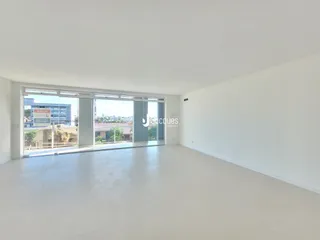 Uma sala de estar ampla com porta de vidro voltada para o exterior.