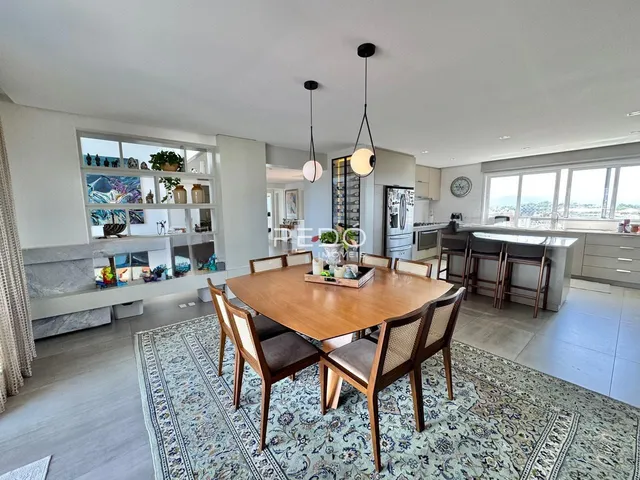 Uma sala de jantar com mesa de madeira e piso de cerâmica.
