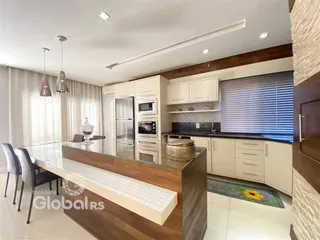 Vista da cozinha moderna com ilha e armários em Lajeado.