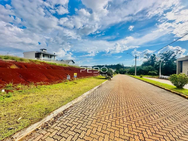 Vista de uma propriedade com terreno inclinado e estrada no Brasil.