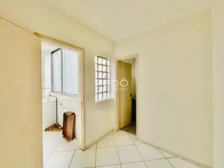 Hall de entrada com piso de cerâmica clara e janela.