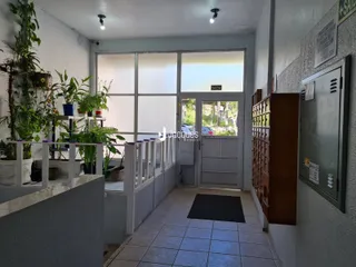 Corredor interno com paredes brancas e piso de cerâmica.