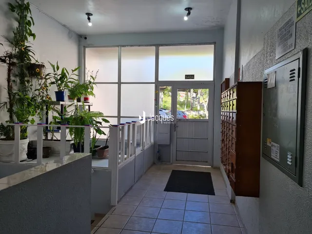 Corredor interno com paredes brancas e piso de cerâmica.