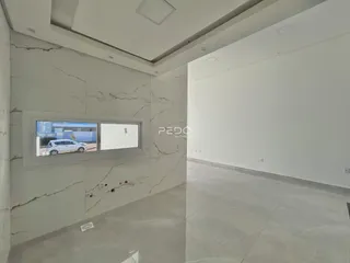 Interior de um ambiente com paredes brancas e acabamento em mármore claro.