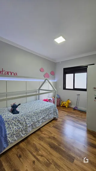 A foto mostra o interior de um quarto com piso de madeira.