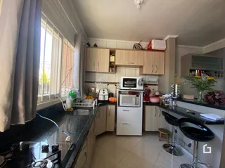 Foto de uma cozinha com armários de madeira e bancadas escuras.