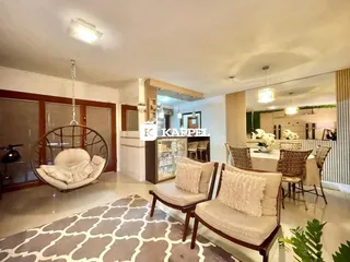 Sala de estar com poltronas de vime e um tapete geométrico no piso.
