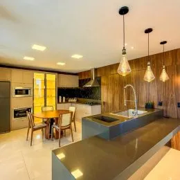 Foto de uma cozinha com armários de madeira e bancada escura.