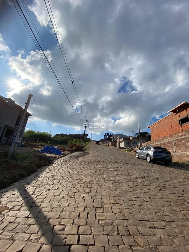 Vista de uma rua pavimentada em Lajeado, Brasil, com edificações ao fundo.
