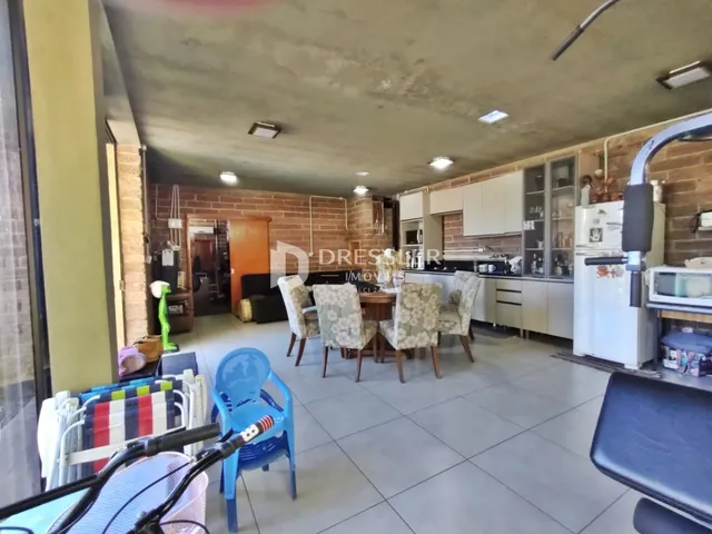 Interior de uma cozinha e sala de jantar com paredes de tijolo aparente.
