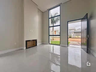 Interior de uma sala de estar moderna com piso claro e grande janela.