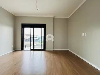 Sala de estar com piso de madeira e porta de vidro grande.