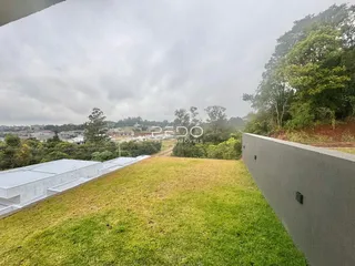 Gramado grande de um terreno com uma parede lateral.