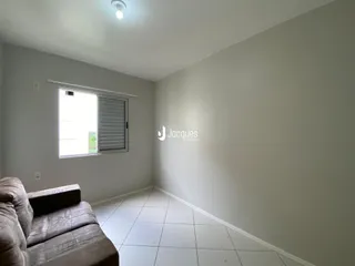 Sala de estar com piso claro e janela na parede.