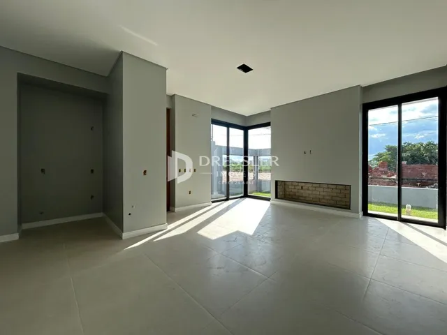 Ambiente interno amplo com piso claro e paredes cinzas.