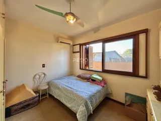 Quarto interno com cama e janela em uma residência.