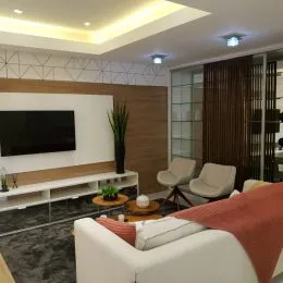 Foto de uma sala de estar com televisão e estante de madeira.
