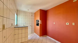 Hall de banho com paredes revestidas de azulejos claros e uma parede laranja.