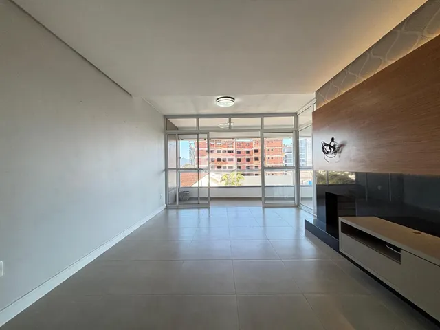 Sala de estar com piso de cerâmica e vista para o exterior.