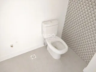 Foto de um banheiro com vaso sanitário branco e parede branca.