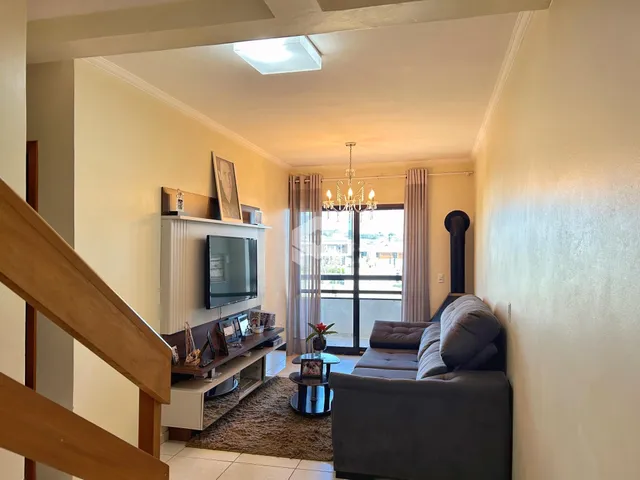 Sala de estar com sofá e televisão em um apartamento no Brasil.
