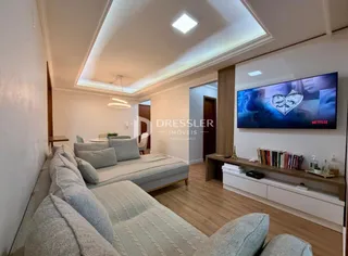 Sala de estar moderna com sofá e televisão.