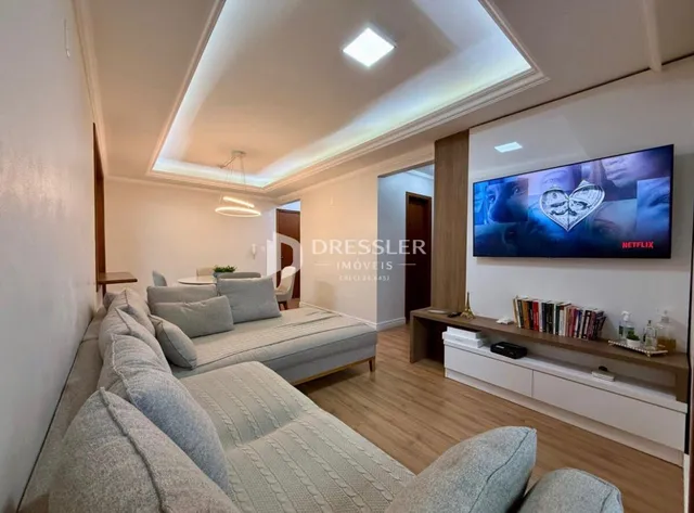 Sala de estar moderna com sofá e televisão.