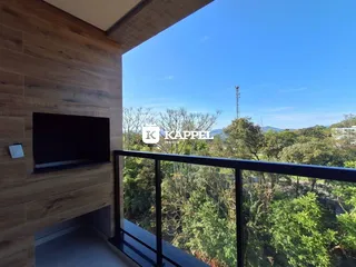 Vista panorâmica da varanda com vegetação densa e montanhas ao fundo.